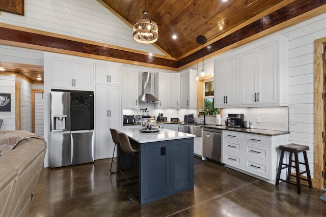 kitchen with concrete floors, a sink, stainless steel appliances, wood ceiling, and wall chimney range hood