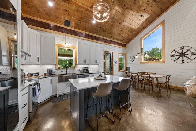 kitchen with wooden ceiling, concrete flooring, a wealth of natural light, and a sink