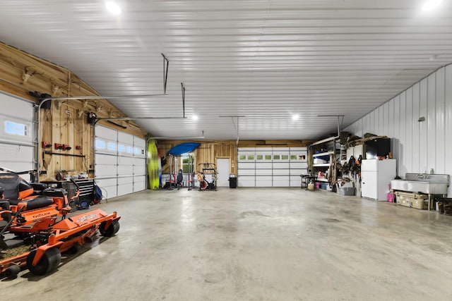 garage with metal wall and freestanding refrigerator