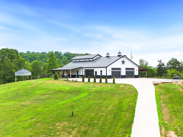 modern farmhouse style home featuring a gazebo, driveway, and a front lawn