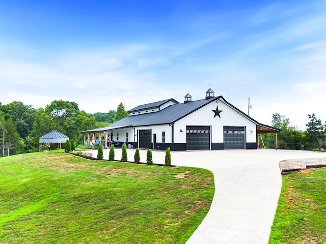 modern farmhouse style home with a gazebo, metal roof, driveway, and a front lawn