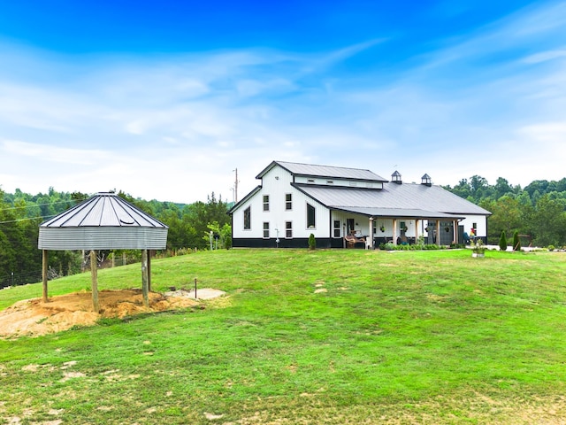 exterior space featuring a lawn, metal roof, and a standing seam roof