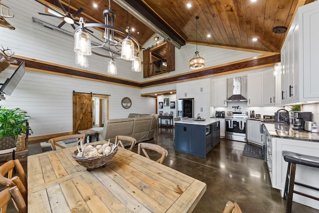 dining space with beam ceiling, high vaulted ceiling, a barn door, concrete floors, and wood ceiling