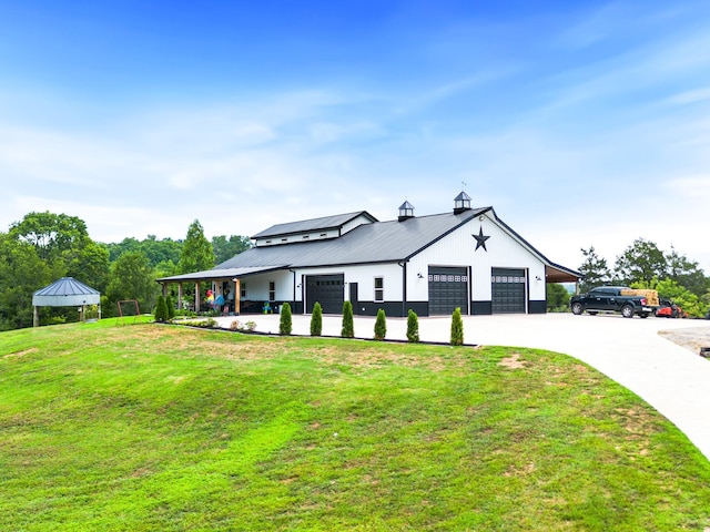 modern inspired farmhouse featuring a standing seam roof, a front yard, driveway, and metal roof