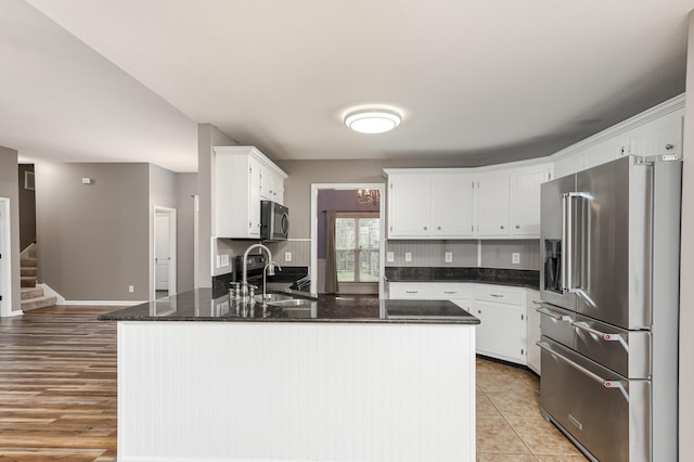 kitchen featuring a sink, white cabinetry, a peninsula, light tile patterned flooring, and high end refrigerator