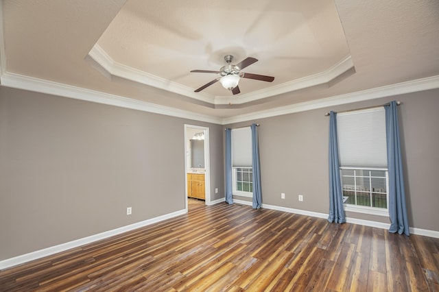 unfurnished room featuring a tray ceiling, wood finished floors, crown molding, baseboards, and ceiling fan