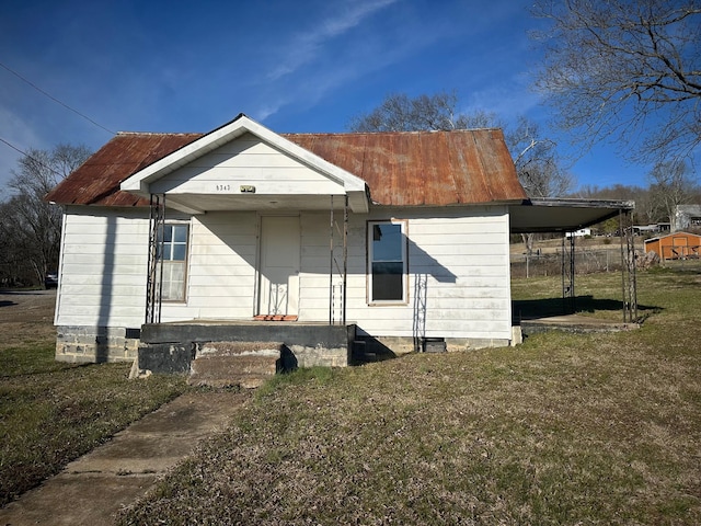 rear view of house with a lawn and metal roof