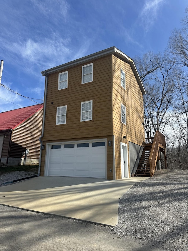 view of front of property with stairway, an attached garage, and driveway