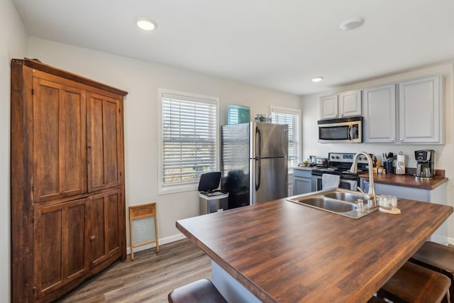 315B Bill Hunter Rd, Celina, TN 38551 - kitchen featuring butcher block countertops, a sink, stainless steel appliances, light wood finished floors, and baseboards