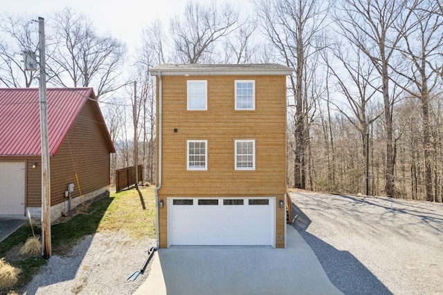 view of front of house featuring concrete driveway, a garage, and metal roof