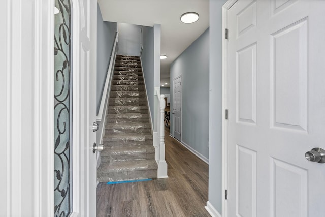 stairway featuring baseboards and wood finished floors