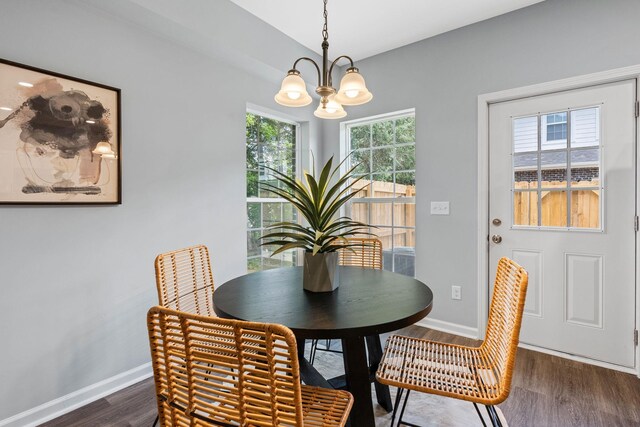 dining room featuring a notable chandelier, dark wood-style floors, and baseboards