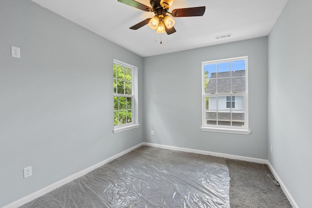 empty room with visible vents, baseboards, and ceiling fan