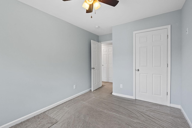 unfurnished bedroom featuring a ceiling fan and baseboards