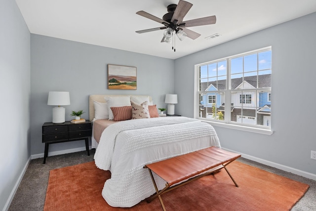 carpeted bedroom with visible vents, baseboards, and ceiling fan