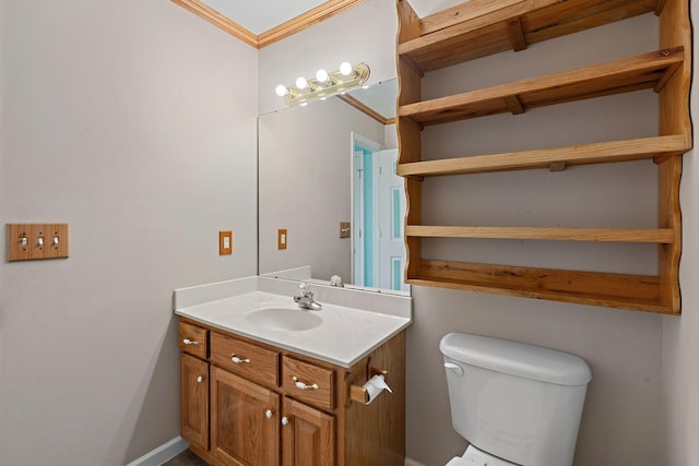 bathroom with baseboards, toilet, ornamental molding, and vanity