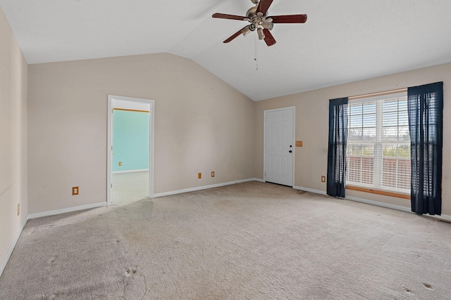 carpeted empty room featuring baseboards, lofted ceiling, and a ceiling fan