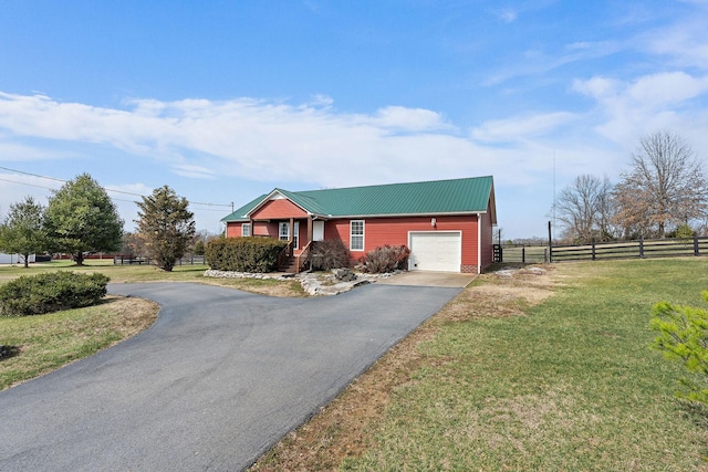 view of front of house with a front yard, fence, a garage, aphalt driveway, and metal roof