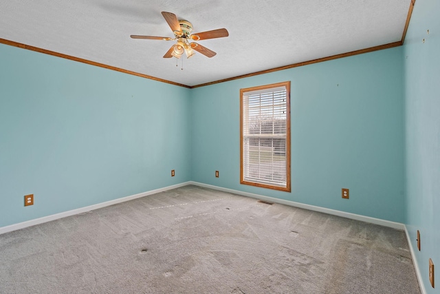 unfurnished room featuring baseboards, ceiling fan, a textured ceiling, crown molding, and carpet flooring