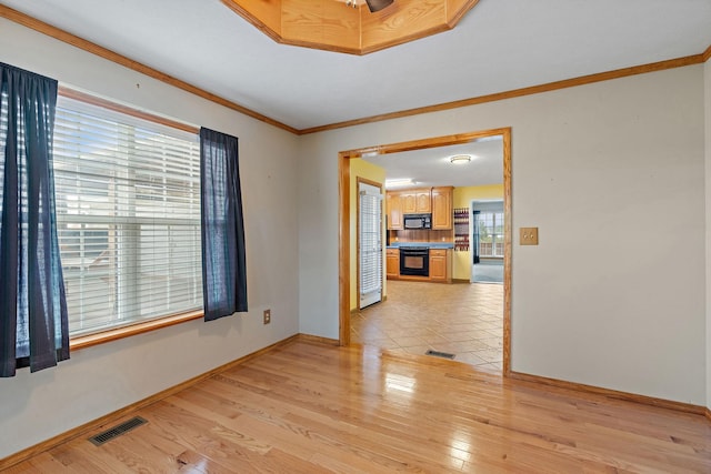 unfurnished room with ornamental molding, baseboards, visible vents, and light wood-type flooring