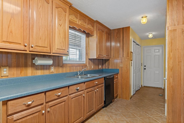 kitchen featuring a sink, brown cabinets, black dishwasher, and light tile patterned floors