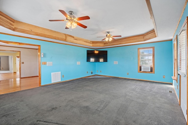 spare room with visible vents, crown molding, a raised ceiling, and carpet floors