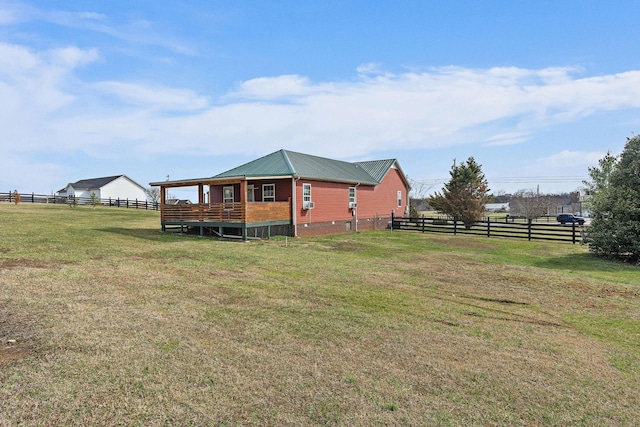 exterior space featuring metal roof, a yard, and fence