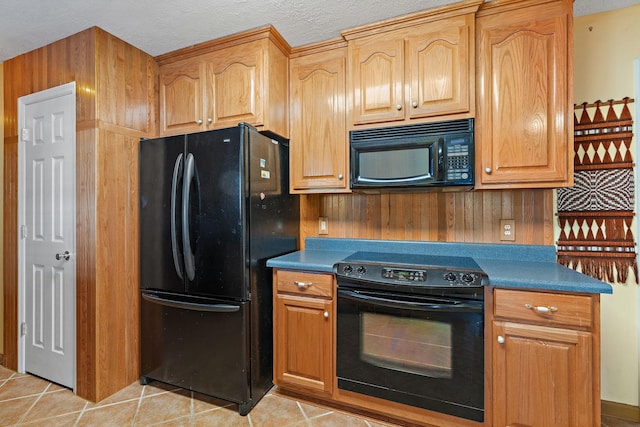 kitchen with black appliances, light tile patterned flooring, and dark countertops