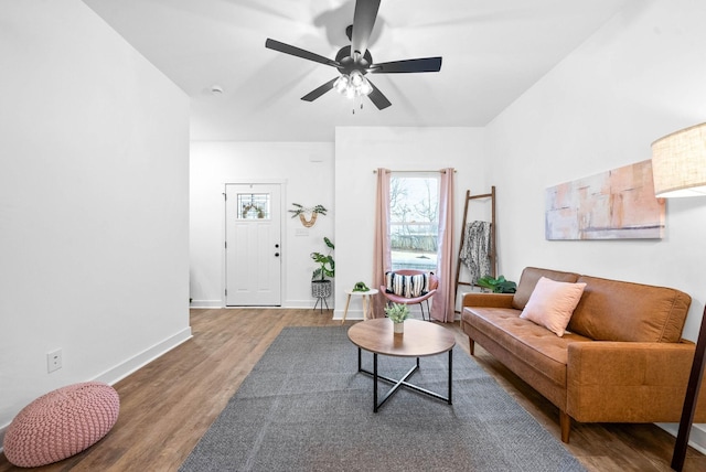 living area featuring a ceiling fan, wood finished floors, and baseboards