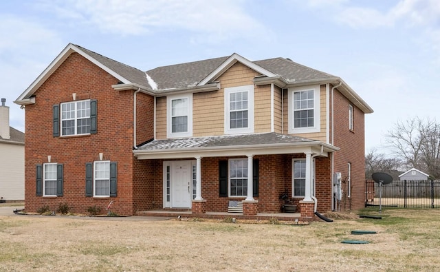 view of front of property with brick siding, a front yard, and fence