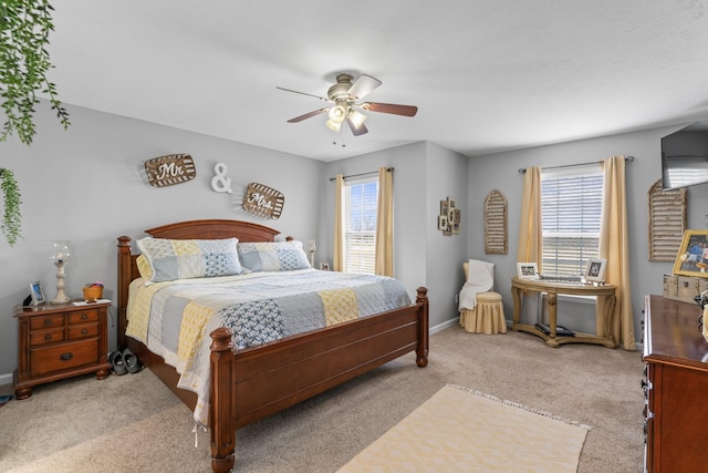 bedroom featuring multiple windows, baseboards, carpet floors, and ceiling fan