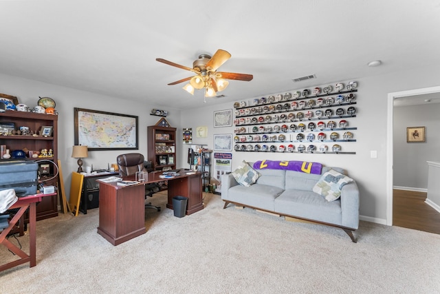 office featuring visible vents, light carpet, baseboards, and ceiling fan