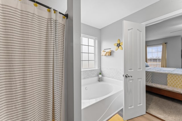 bathroom with connected bathroom and a garden tub