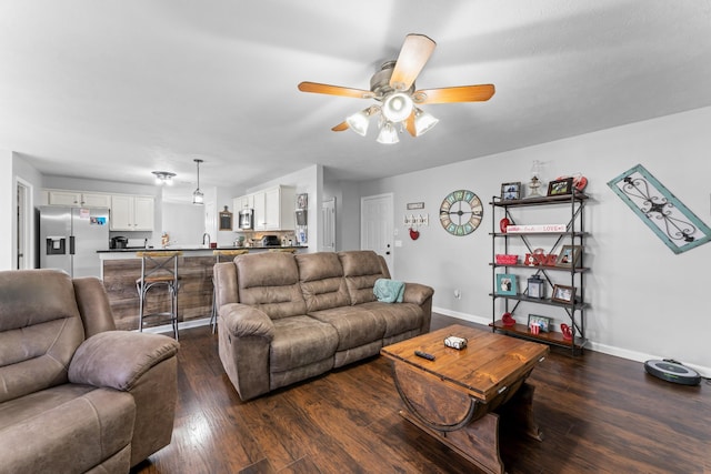 living area featuring dark wood finished floors, a ceiling fan, and baseboards