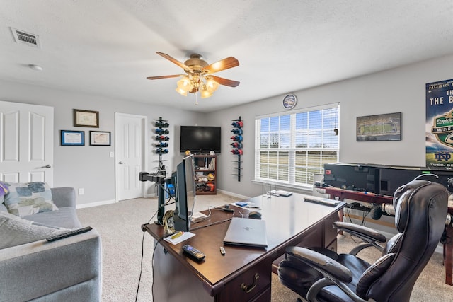 office featuring visible vents, carpet flooring, baseboards, and a ceiling fan