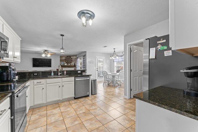 kitchen with white cabinets, a peninsula, stainless steel appliances, and a sink