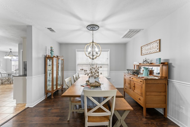 dining room with visible vents, an inviting chandelier, and a wainscoted wall