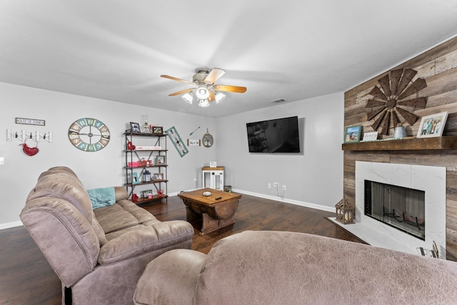 living room with visible vents, a ceiling fan, wood finished floors, a premium fireplace, and baseboards