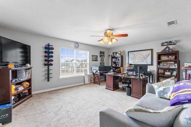 carpeted office space with a ceiling fan, baseboards, visible vents, and a textured ceiling