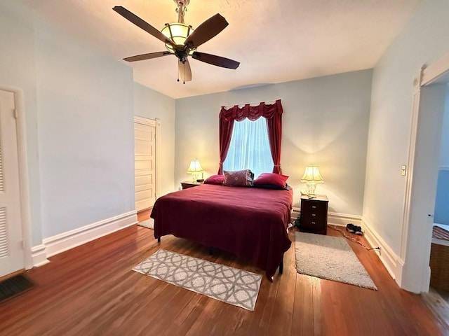 bedroom featuring wood finished floors, baseboards, and ceiling fan