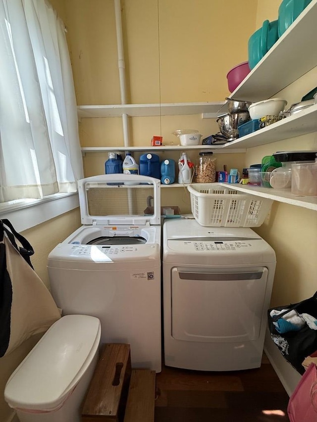 laundry room with independent washer and dryer, wood finished floors, and laundry area