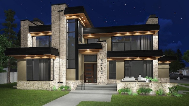 view of front of house with stucco siding, stone siding, and a balcony