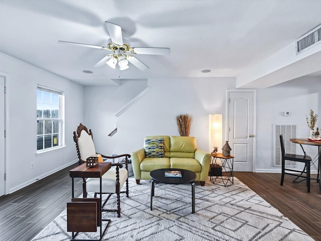 living room featuring wood finished floors, visible vents, and baseboards