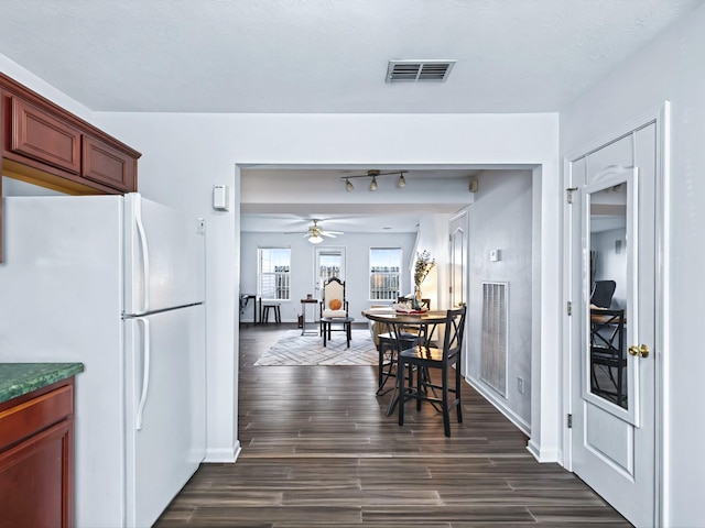 dining space with ceiling fan, visible vents, and dark wood finished floors