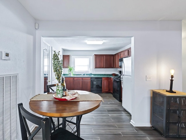 kitchen with visible vents, dark brown cabinets, baseboards, wood tiled floor, and black appliances