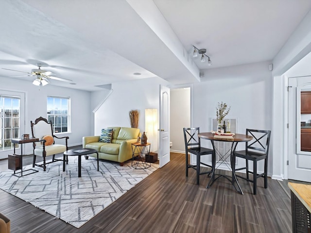 living room with rail lighting, a ceiling fan, baseboards, and dark wood-style flooring