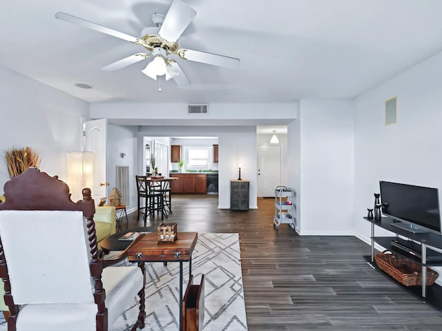 living room featuring dark wood finished floors, baseboards, visible vents, and ceiling fan