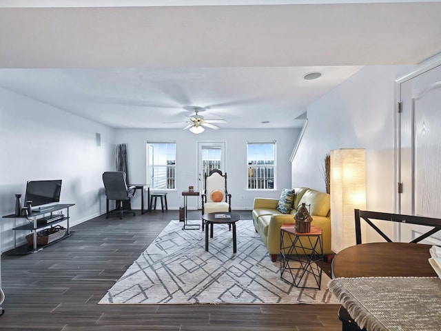 living room featuring ceiling fan, baseboards, and wood finished floors