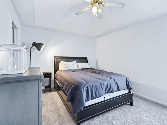 bedroom featuring a tray ceiling, baseboards, carpet floors, and ceiling fan