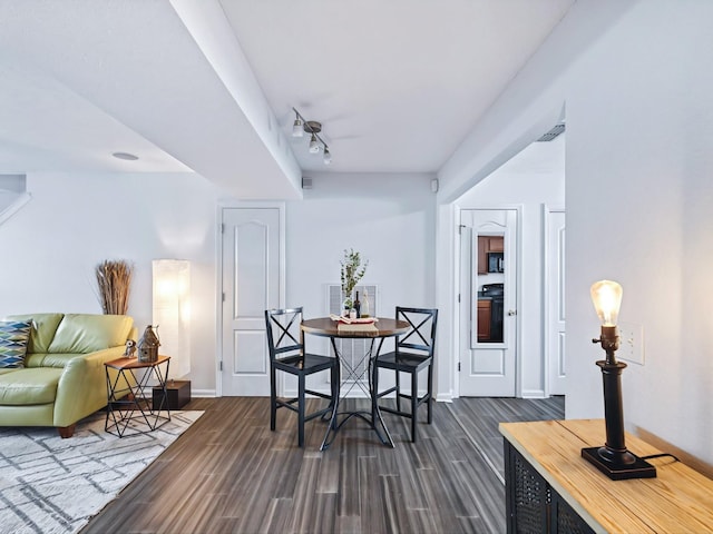 dining room with track lighting, baseboards, dark wood-style flooring, and visible vents